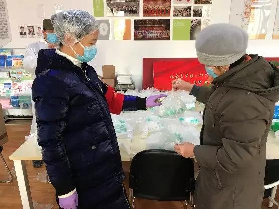 為樓棟分發(fā)口罩，并為包裝袋消毒